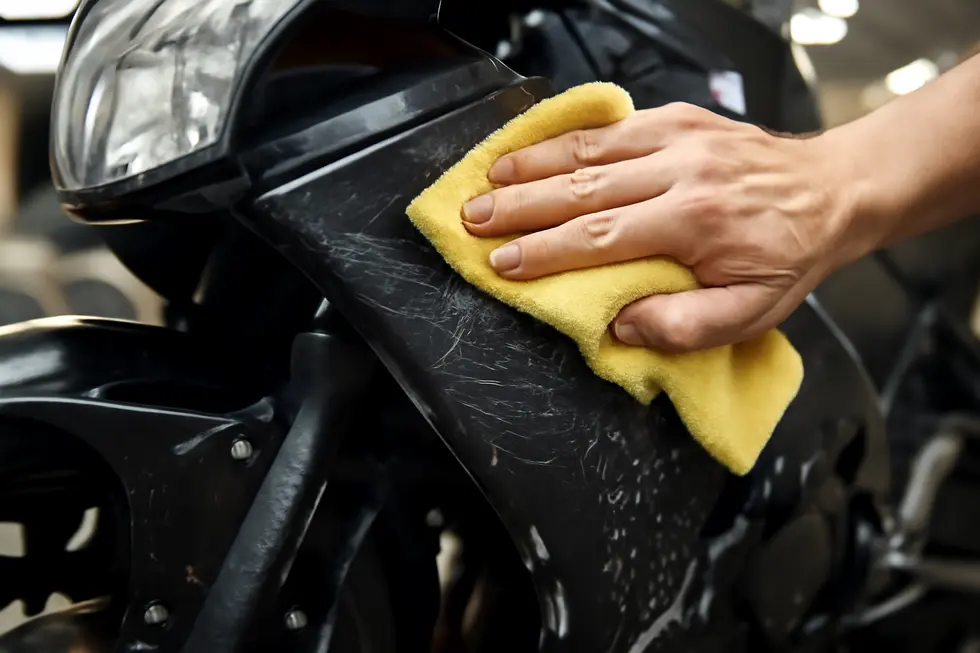 Thorough cleaning of a scratched motorcycle fairing to prepare the surface for effective repair.