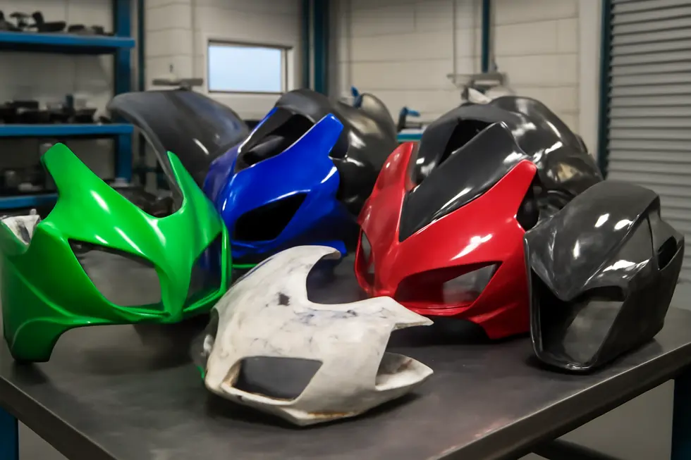 Professional motorcycle workshop with various repaired and customized fairings showcasing ABS plastic and carbon fiber finishes.